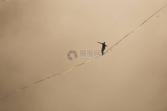 一个人沿着高在云层上方的拉长吊索行走highliner在峡谷中通过长而高的吊索拉力来保持平衡波斯尼亚和黑萨哥维那图片