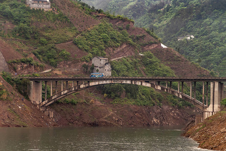 长江西岭峡谷棕色混凝土弓桥与蓝色公共巴士在小支流上图片