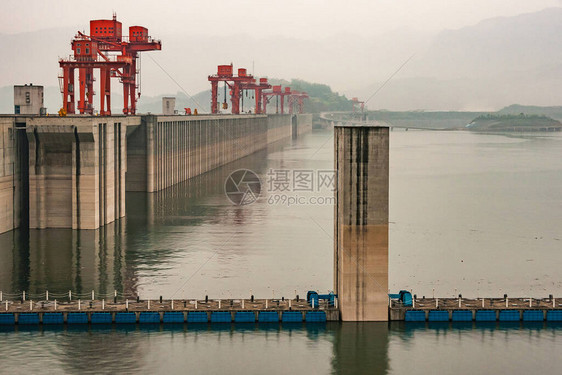 沿着棕色混凝土墙与红色起重机在绿色水面上的游特写镜头图片