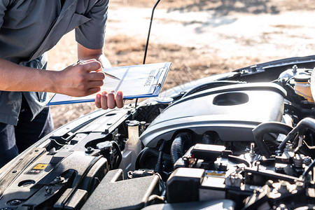 技术工程师工作的汽车修理工在做修理引擎的清单写到剪贴板修理车辆服务和图片