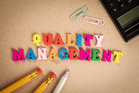 质量管理审计监控和服务理念纸板背景上彩色木图片