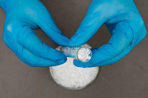 塑料颗粒聚乙烯球和戴手套的手生产中的实验室对塑料的质量控制图片