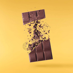 巧克力棒片在空中飞翔在黄色背景上隔离高分辨率图像食品浮游概念图片