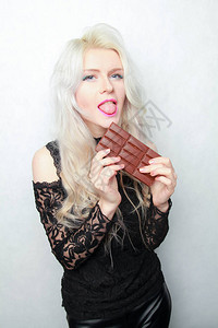 年轻女孩吃巧克力棒孤立图片