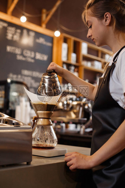 使用chemex准备咖啡的专业咖啡师倒在咖啡机和滴水壶上煮咖啡的年轻女人冲泡咖啡的替代方法图片