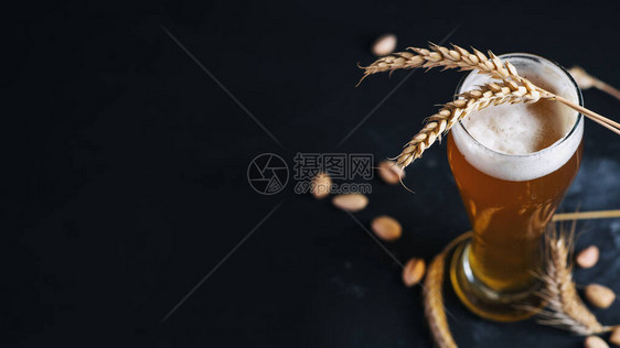 黑桌上一杯小麦啤酒,有小麦和图片
