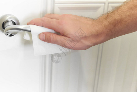 用纸巾抗的人手清洁消毒的金属门把手门把手图片