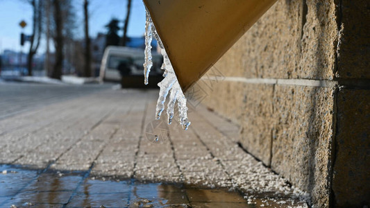 排水管上的冰融化在泉水沟里流水在春初背景图片