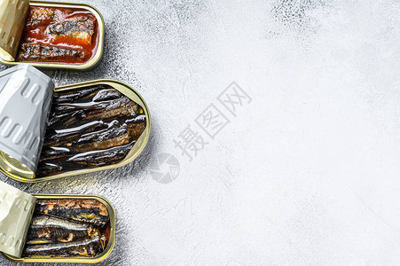 沙丁鱼罐头鱼烟熏沙丁鱼鲭鱼灰色的木制背景顶视图片