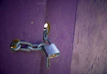 紫色门上的挂锁和链子背景图片
