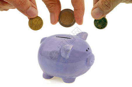 用手把欧元硬币放进小猪银行关图片