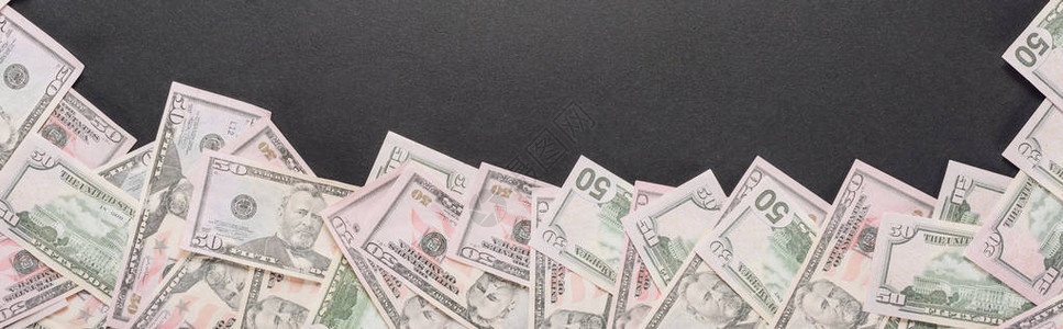 灰色背景上散落的美元钞票的顶部视图图片