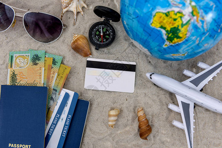 带飞机护照和机票在沙图片