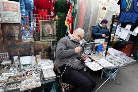 利沃夫市场的努米斯马特主义者在手机上读到图片