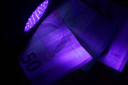 紫外闪光灯束中的钞票图片