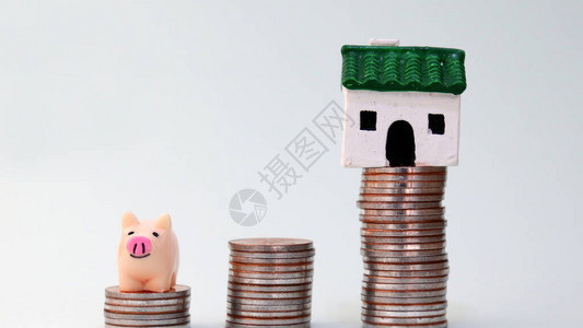 一只小猪银行和一栋迷你房子在一图片
