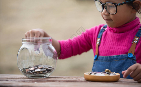 小女孩和堆积硬币储蓄图片