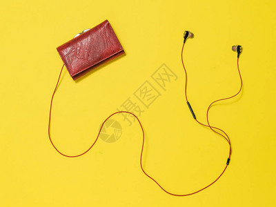 女人的红色钱包和黄色背景的红耳机时尚图片
