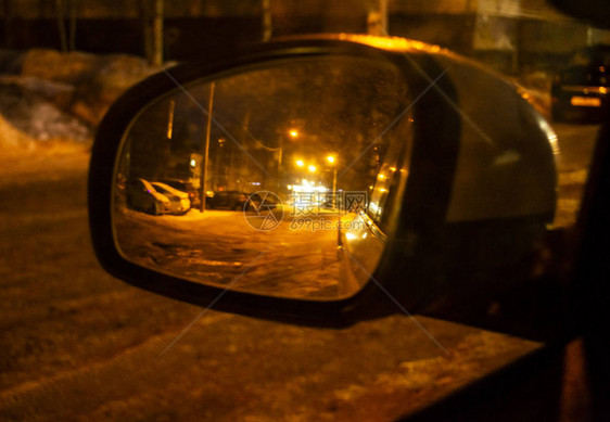 汽车侧面镜子模糊的夜晚反射着冬天的道路图片