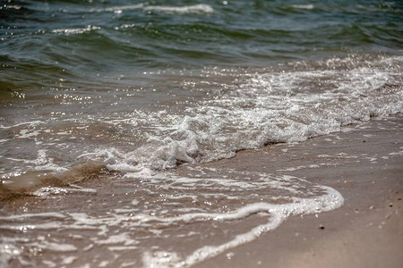 海浪溅在沙滩的岸边图片