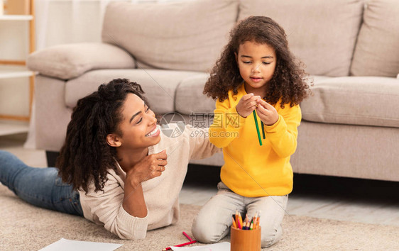 黑人母亲和女儿在家中一起玩黑妈和女儿的拼图游图片