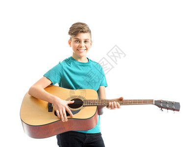 在白人背景下玩吉他的少年男孩Teenag图片