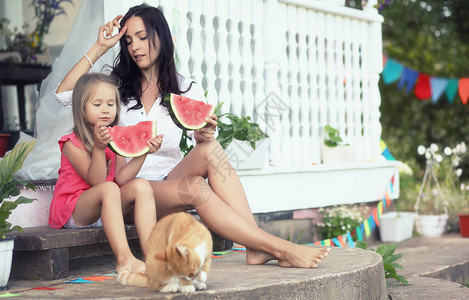 吃一个多汁的红西瓜的年轻家庭背景图片