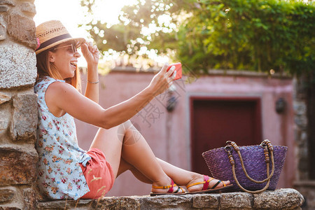 旅游女客在暑假用智能手机拍摄旅图片