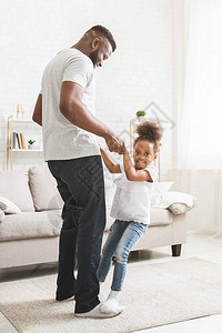 年青的非洲父亲和小可爱的女儿在家玩得开心图片
