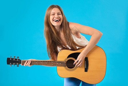 美丽的年轻女子带着吉他在彩色背景上图片
