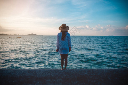 一个女人看着并站在海滩的风景上有着图片