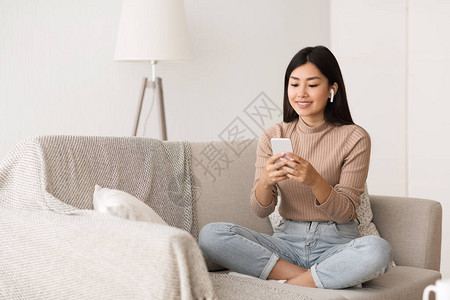 亚洲女孩用耳膜听音乐在家过周末图片