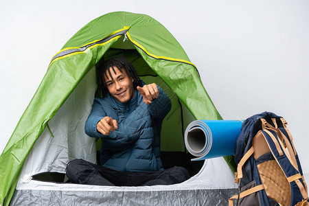 年轻美国人在露营的绿色帐篷里微笑时用手指图片