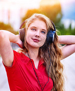 学生带耳机的女孩在考试后听音乐该是在街头城市放松了步行会图片