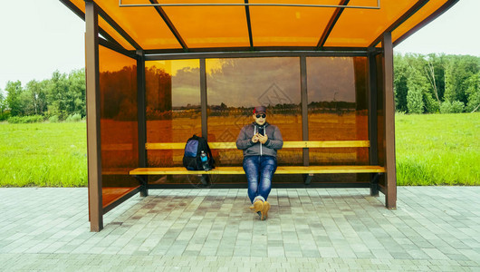 喜悦的年轻人正在公共汽车站等待交通工具图片
