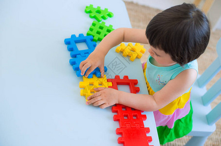 一个3岁的孩子在一张桌子旁玩着五颜六色的玩具积木孩子们在幼儿园或房间里玩益智玩具学龄前儿童在桌子上用塑图片