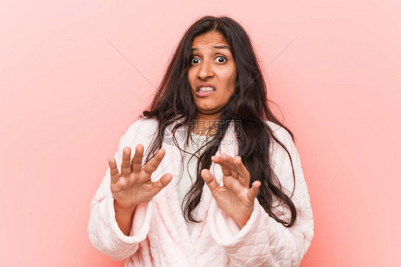 穿着睡衣的年轻印度女人拒绝一个表现出厌恶姿态的人图片