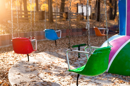空椅子多彩姿的链条秋千旋转木马在老式复古娱乐游园秋季日落晚上户外过去的童年记忆概念隔离封背景图片