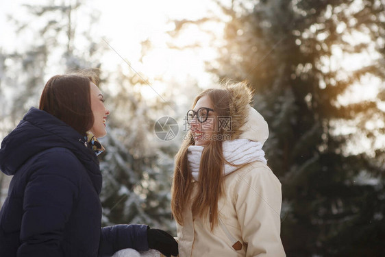 两个穿长发围巾和夹克的年轻美女在雪林户外聊天很愉快青春美丽健康的生活方式梦图片