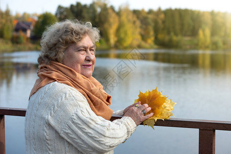 一个快乐的老女人在河边秋图片