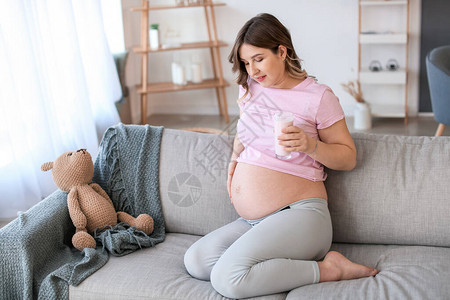 美丽的孕妇在家里喝酸图片