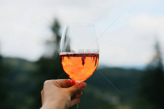 Aperol在山地背景暑假和度假胜地同时饮用Aperol妇女以美味的橙子鸡尾酒欢呼图片