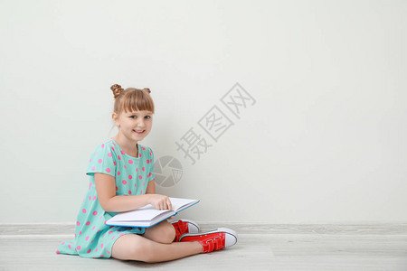 可爱的小女孩有书在背景图片