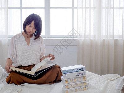 躺在床上看书的女孩图片