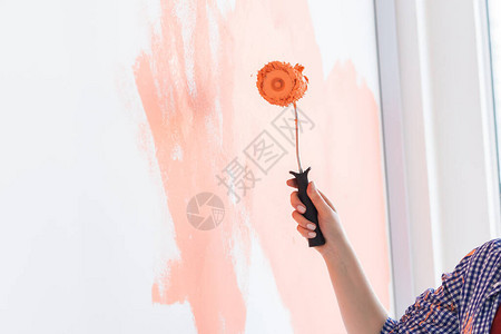 美容女在新公寓的油漆墙上画翻新和图片