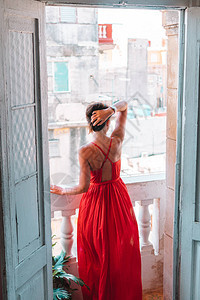 在古巴旧哈瓦那的公寓里穿红衣服的妇女穿着红图片