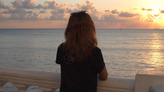 日落时站在海景背上的年轻女子的背影媒体有魅力的女人站在路堤上图片