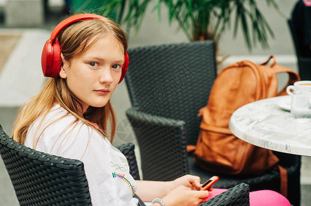 年轻女孩在咖啡馆休息戴耳机图片