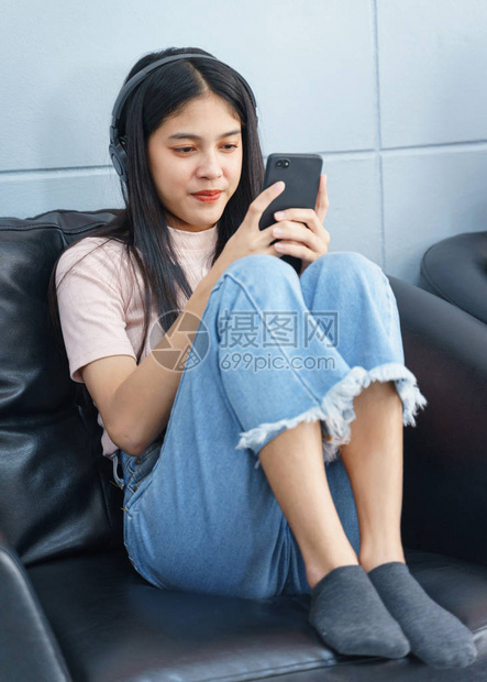 亚洲青少年花空闲时间阅读书籍和玩手机图片