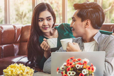 快乐的亚洲情侣在家里喝咖啡爱情关系和生活方式的概图片